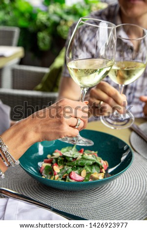 Happy lovers, attractive woman and man enjoy the romance. Attractive couple making selfie, smiling and having fun together. A couple eating salads, drinking wine with taking photos.