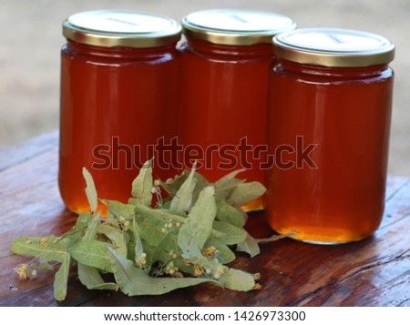 linden wild flowers honey on wooden table Royalty-Free Stock Photo #1426973300