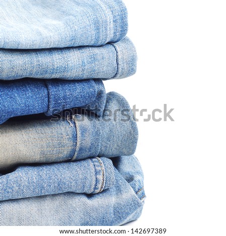 Stack of blue jeans on white background
