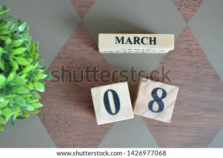 Date of March with leaf on diamond pattern table for background.