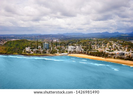 Picture of a big city located on a coast, taken on a cloudy day with moutains seen in the horizon, surfers paradise