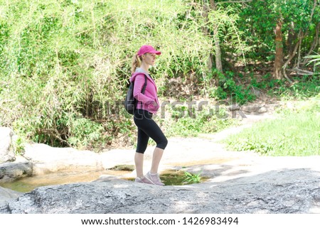 Women walking around, exercising with a pink jacket and a backpack on a mountain in Thailand And go to sit and relax, sip coffee and meditate to increase happiness for themselves