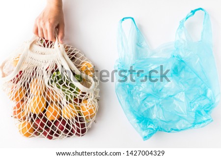 Top view of mesh shopping bag with organic eco fruits isolated on white background. Caring for the environment and the rejection of plastic concept