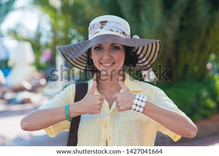 girl traveler shows well. Resting girl with hat and men's yellow shirt.