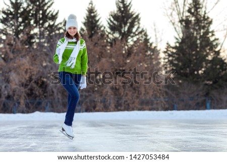 Happy woman in skates in winter, winter sport and winter entertainment concept.