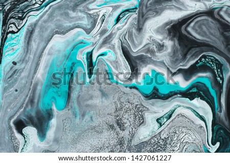photography of abstract marbleized effect background. black, light turquoise and white creative colors. Beautiful paint