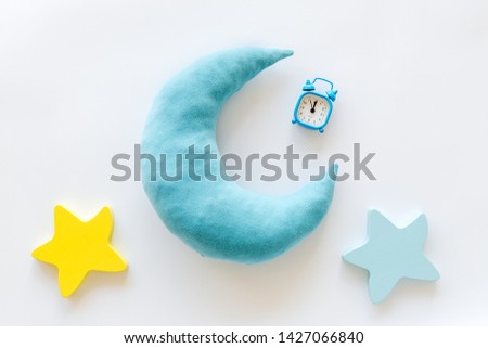 Night sleep concept with moon, stars toy and alarm clock on white background top view