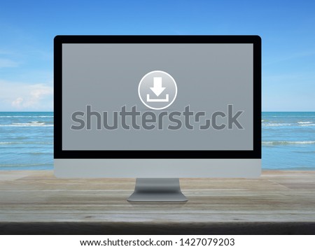 Download flat icon on desktop modern computer monitor screen on wooden table over tropical sea and blue sky with white clouds, Technology internet concept