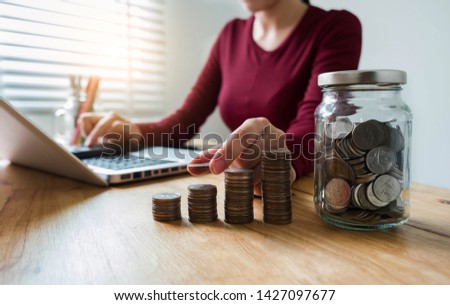 businesswomen holding coins putting in glass with using  calculator to calculate concept saving money for finance accounting.