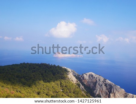 Beautiful summer seascape. Mountain coast of the blue sea. Rocks and forest near the ocean coast.