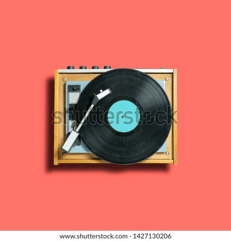 vintage turntable vinyl record player on coral background. retro sound technology to play music. trendy 2019 color concept Royalty-Free Stock Photo #1427130206