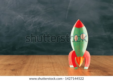 education and back to school concept. cardboard rocket in front of classroom blackboard