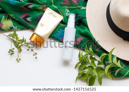 natural cosmetics sunscreen spf50 ,collagen water for health care skin face with green scarf ,hat of lifestyle woman relax summer decoration flat lay style on background white 