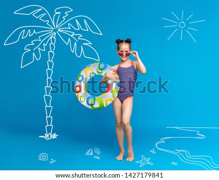 Sea resort. Little girl with inflatable ring on beach, enjoying summer holidays, blue background with creative picture