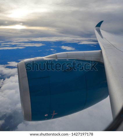 Blue engine of passenger airplane in the sky with cloudscape background.