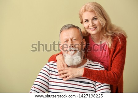 Portrait of mature couple on color background
