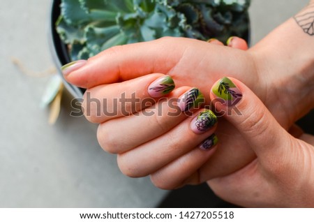 perfect nails design with botanical pattern. Females hands with manicure. Plant concept in nails art.