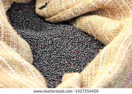 black dried rapeseeds in a canvas bag. close-up Royalty-Free Stock Photo #1427256428