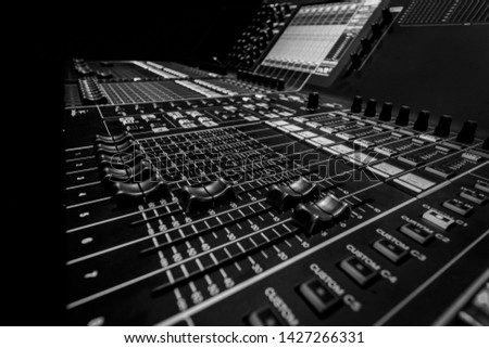 Wide angle closeup of Professional Audio Digital Sound Mixing Control Console. Silver White Faders and black Graphic control Console