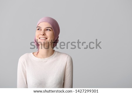 Optimistic woman after chemotherapy on light background Royalty-Free Stock Photo #1427299301