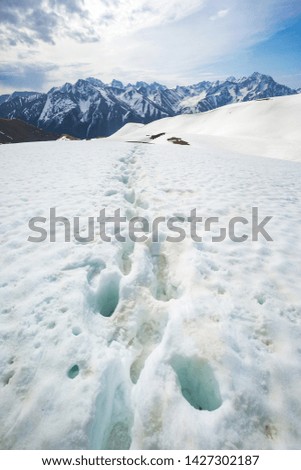Footprints in the snow near Muhu Pass, Karachay-Cherkessia, Russia. Caucasus Mountains landscape.