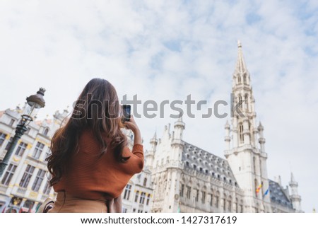 Travelling in Europe, Young woman taking photo by mobile smart phone at grand-palace in Brussels, Belgium in summer