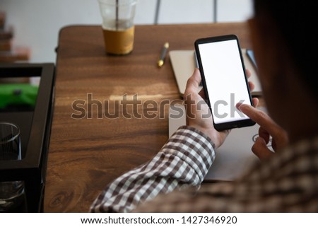 businessman hands searching for data on mock up mobile phone with at his workplace.concept