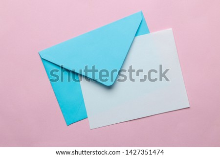 Blue envelope with a blank for text on a bright trendy pink background. top view