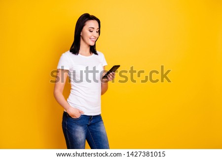 Close up photo beautiful amazing she her lady easy-going reading great good news telephone hand arm millennial texting friends wear casual white t-shirt jeans denim isolated bright yellow background