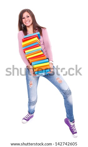 Full length picture of a smiling female student carrying a stack of books over white background. 