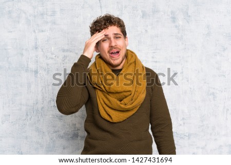 Blonde man over grunge wall has just realized something and has intending the solution