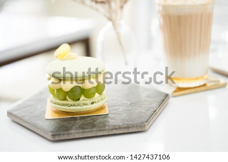 Green macaron cake and drink on the table.
