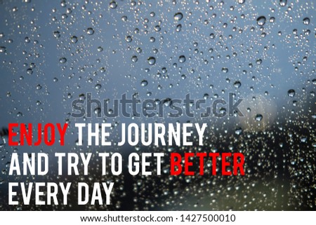 Inspirational motivation quote on the blurred water drops background. Enjoy the journey and try to get better every day.