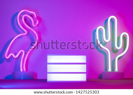 Summer with lightbox and flamingo,cactus neon pink and blue and green light on table with copy space.Trendy vacation holiday background