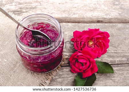 Jam rose petals on a wooden table. Flower confiture. Healthy food. Copy space