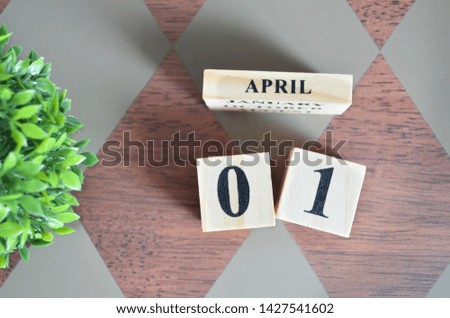 Date of April with leaf on diamond pattern table for background.