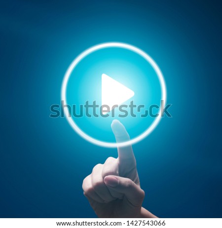 Female finger pushing transparent Play button on blue background