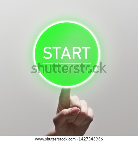 Finger touching green start button on light background, copy space
