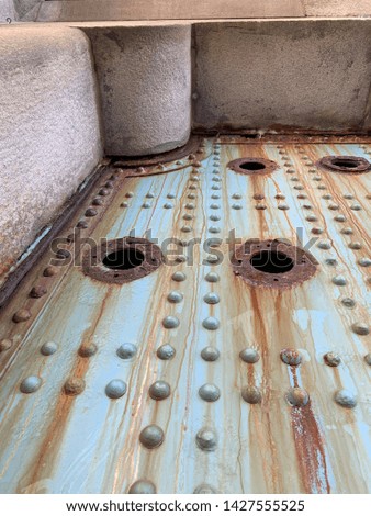 Images of a old rusty door under the Ben Franklin Bridge full of blue chipping paint, rust, bolts and locks.