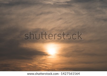 The setting sun covered with thick clouds.