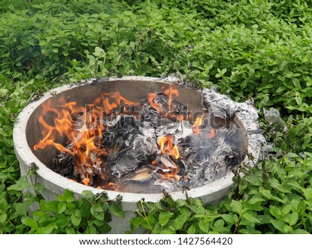 Documents that have not been used and the garbage is burned in a mortar pond among the weeds. pm2.5