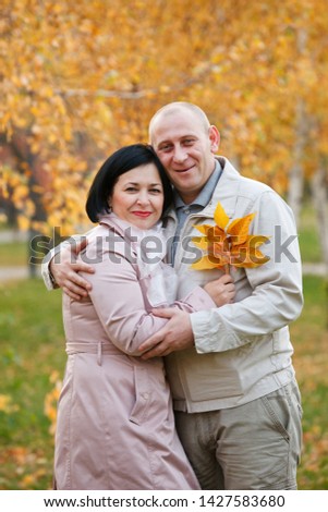 Portrait of married couple in the autumn park.