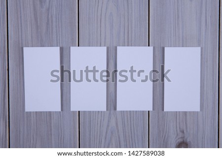 Blank business cards on grey wooden background.