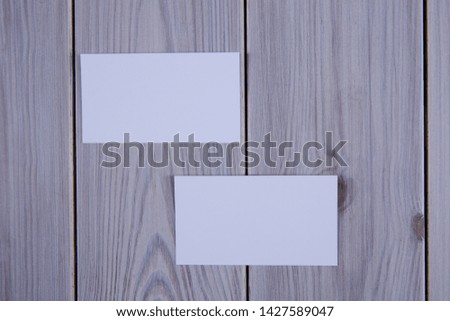 Blank business cards on grey wooden background.