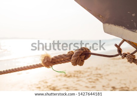 Rope knot of boat on the beach and sun light.