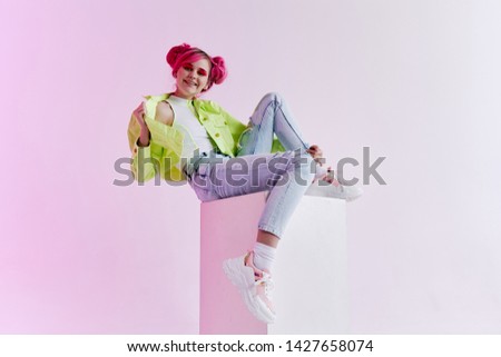 woman with pink hair sits on a cube fashion style