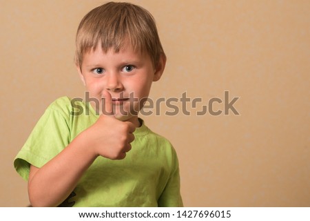 A little boy shows a gesture ok.