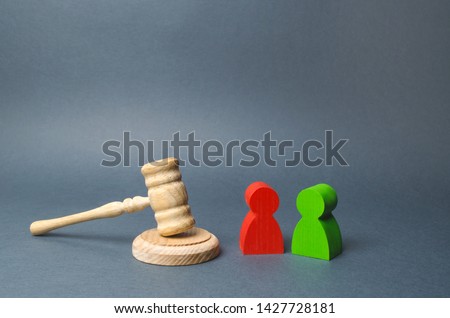 Two figures of people opponents stand near the judge's gavel. The judicial system. Conflict resolution in court, claimant and respondent. Court case, settling disputes. Legal advice, lawyer services. Royalty-Free Stock Photo #1427728181