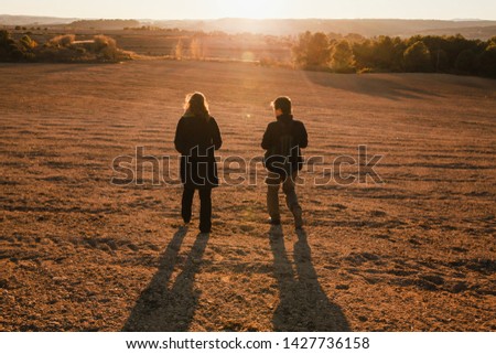 couple walking at sunset in a Large land