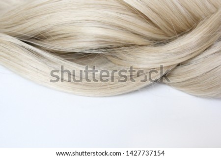 Beautiful wavy hair. Light brown hair. Hair is gathered in a bun on a white background. With free space for text. For a poster or business card.